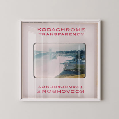 The image is a framed photograph of a scenic view of a river with a bridge in the background.