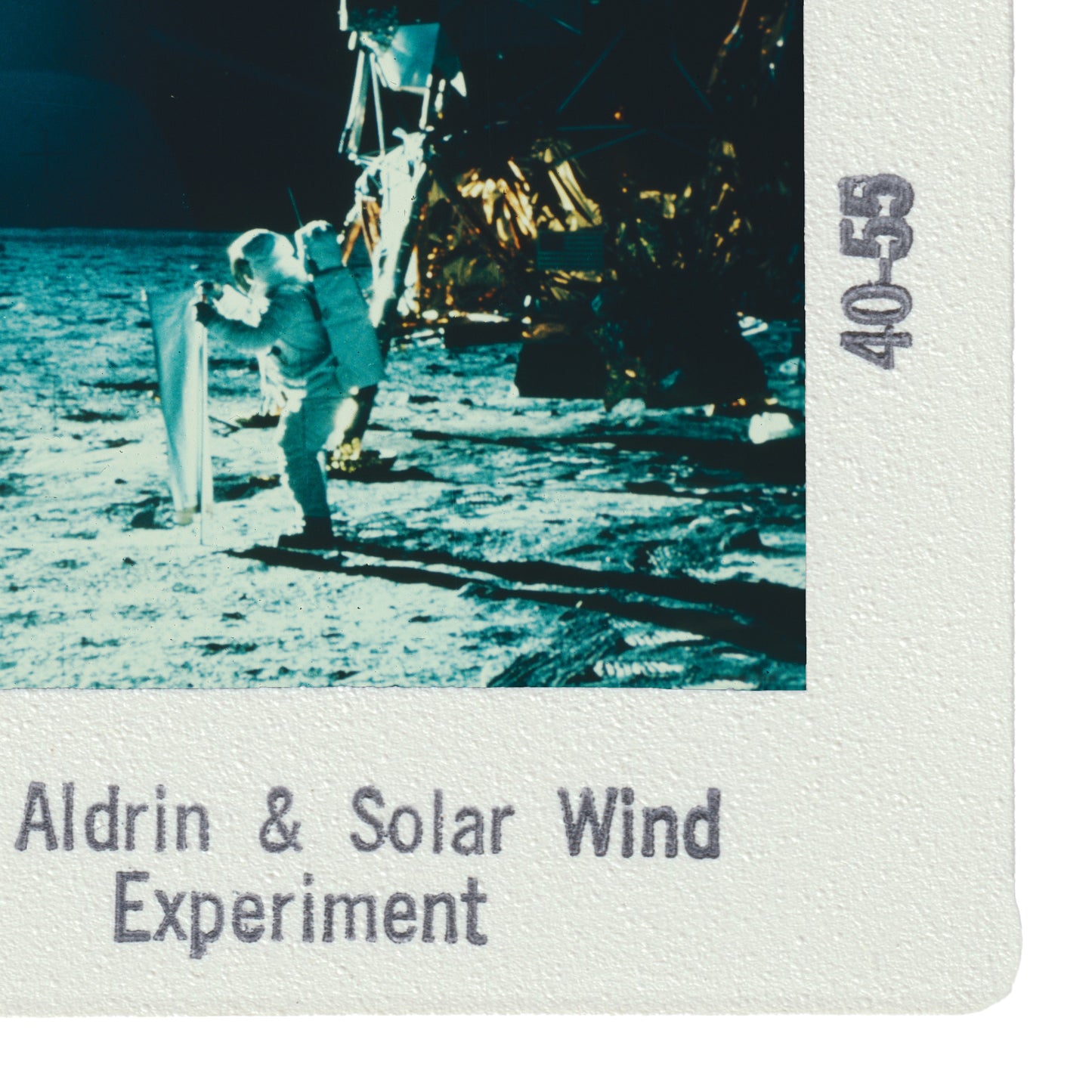 a person in a spacesuit standing on the surface of the moon, with a solar panel attached to their back. The image appears to be part of a solar wind experiment.