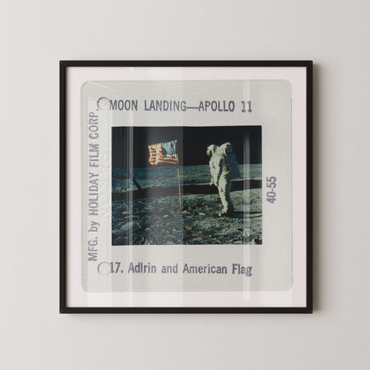 an astronaut walking on the moon's surface, holding an American flag.
