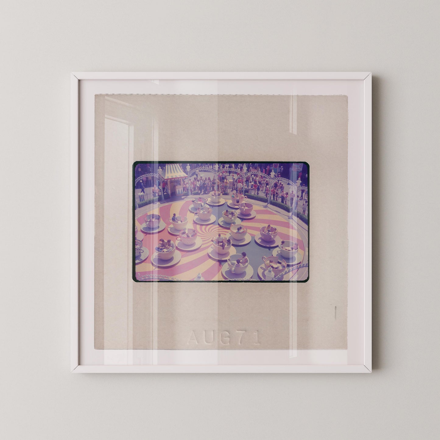 The image is a framed photograph of a carousel with multiple carousel horses in various colors and positions.