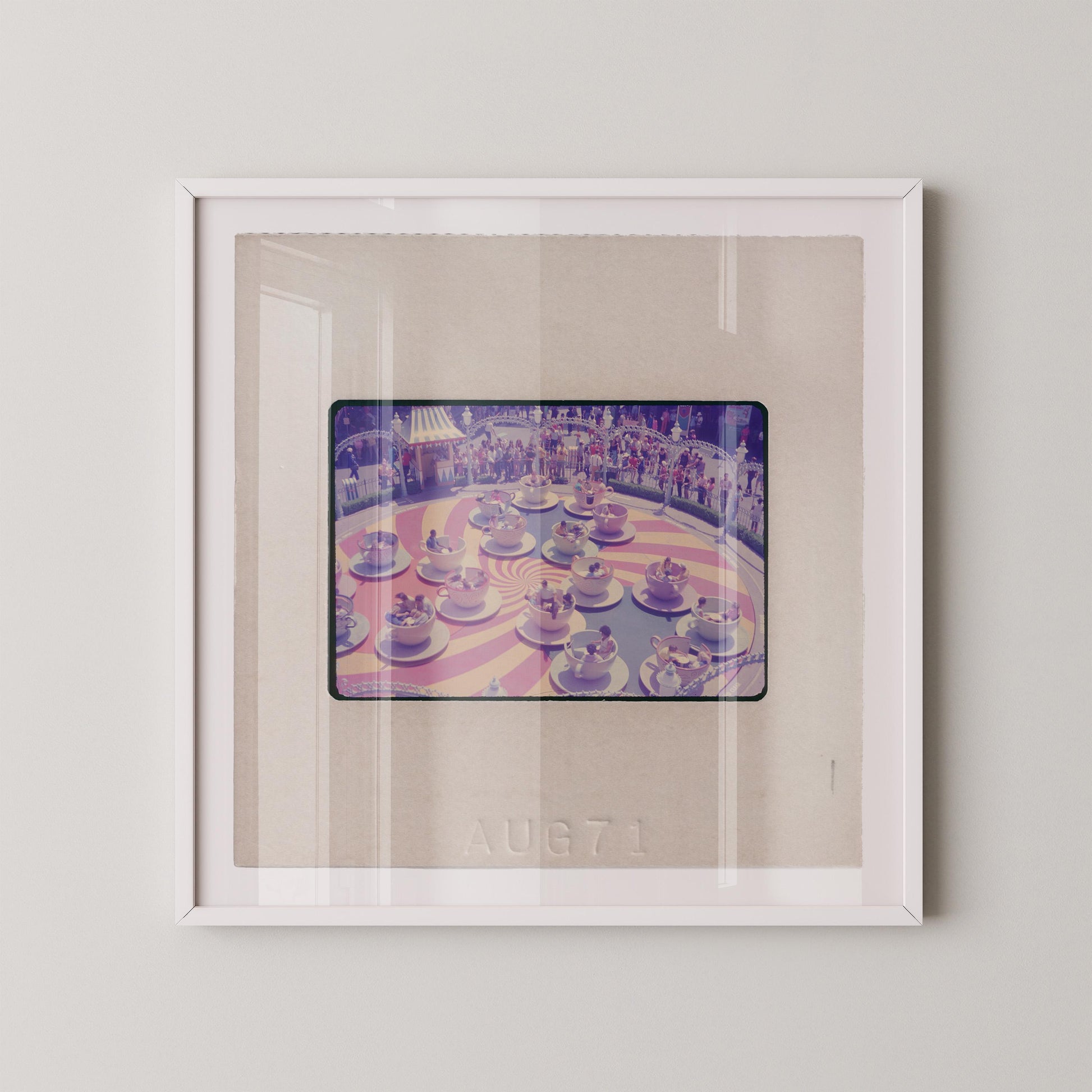 The image is a framed photograph of a carousel with multiple carousel horses in various colors and positions.