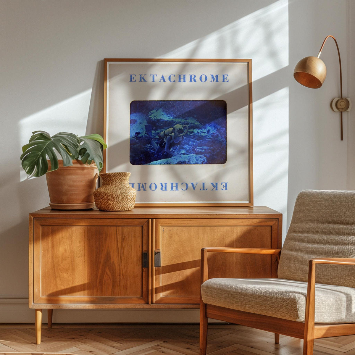 a wooden cabinet with a framed picture of a blue underwater scene, a potted plant, and a woven basket on top. The cabinet is situated in a room with a beige armchair and a lamp on the wall.