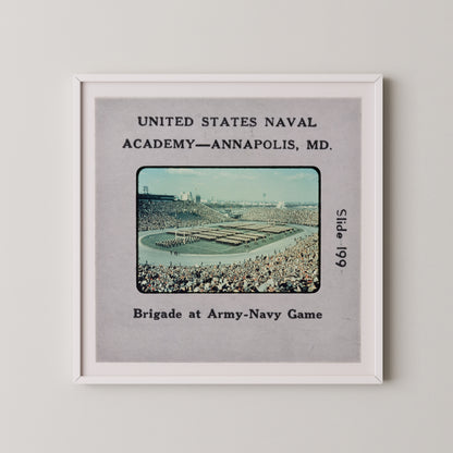 The image is a framed photograph of a large crowd at an Army-Navy game, with a military parade taking place in the background.