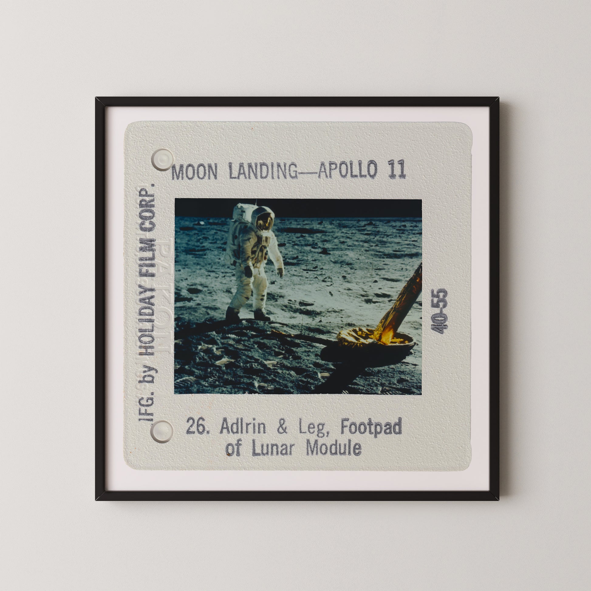 two astronauts walking on the moon's surface, with a lunar module nearby.