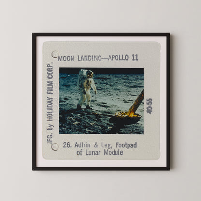 two astronauts walking on the moon's surface, with a lunar module nearby.