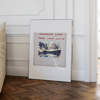 a framed photograph of a scenic mountain landscape, with the text "MORAIN LAKE #EAR LAKE LOUISE" written on the frame.