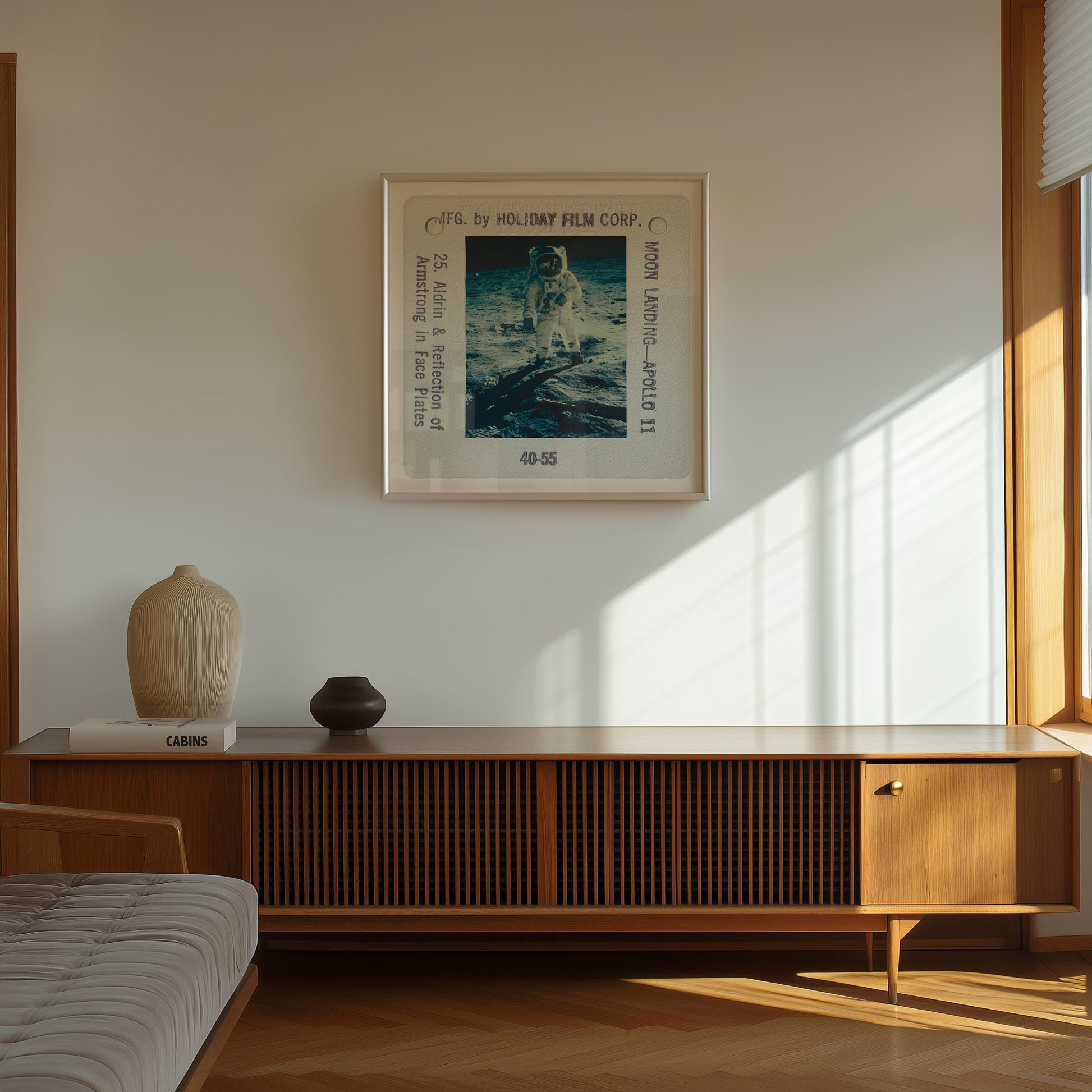 a framed photograph of an astronaut on the wall of a room with a wooden cabinet below it.