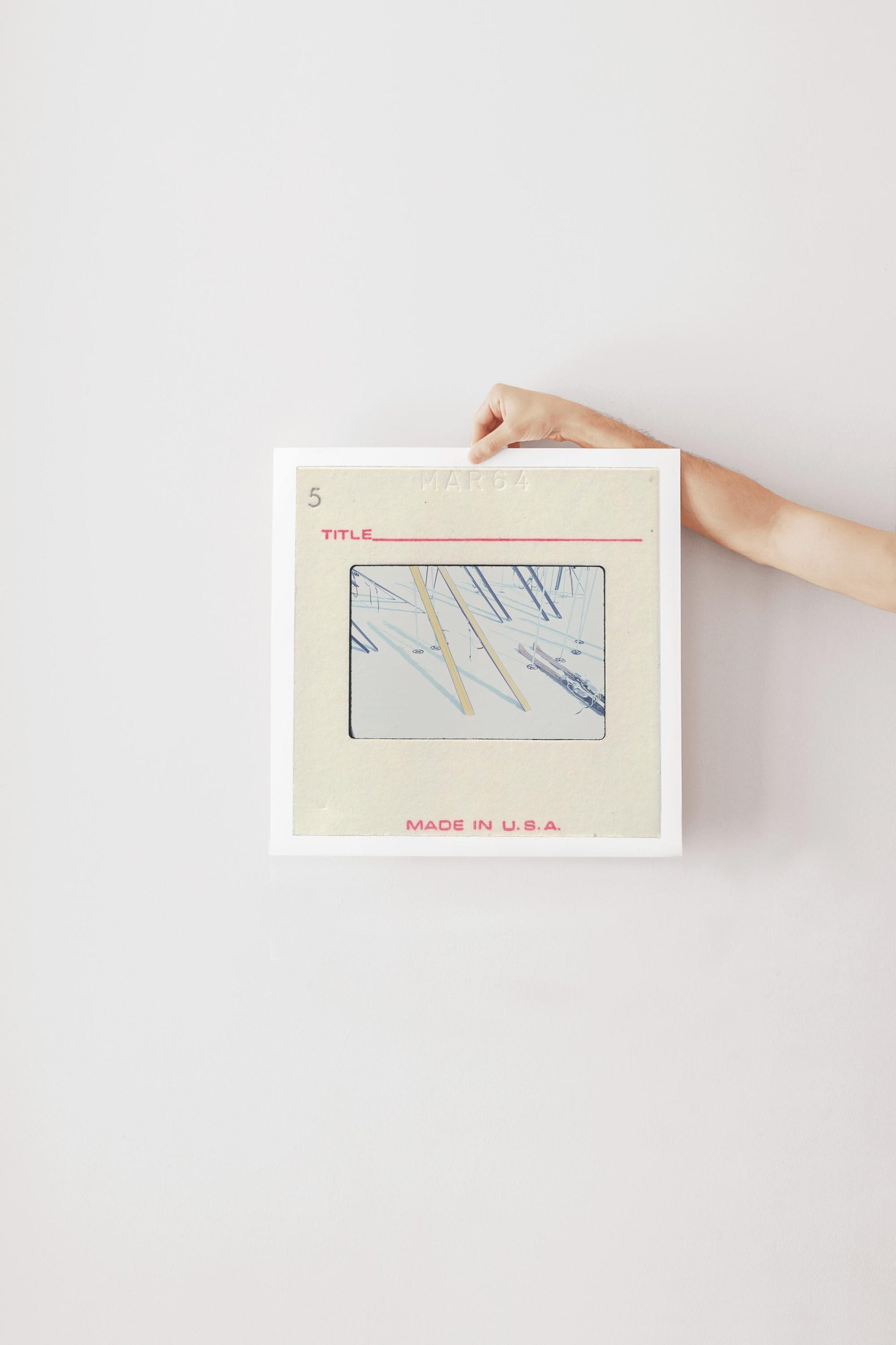 A person's hand is holding a framed image with a title and the text "MADE IN U.S.A."