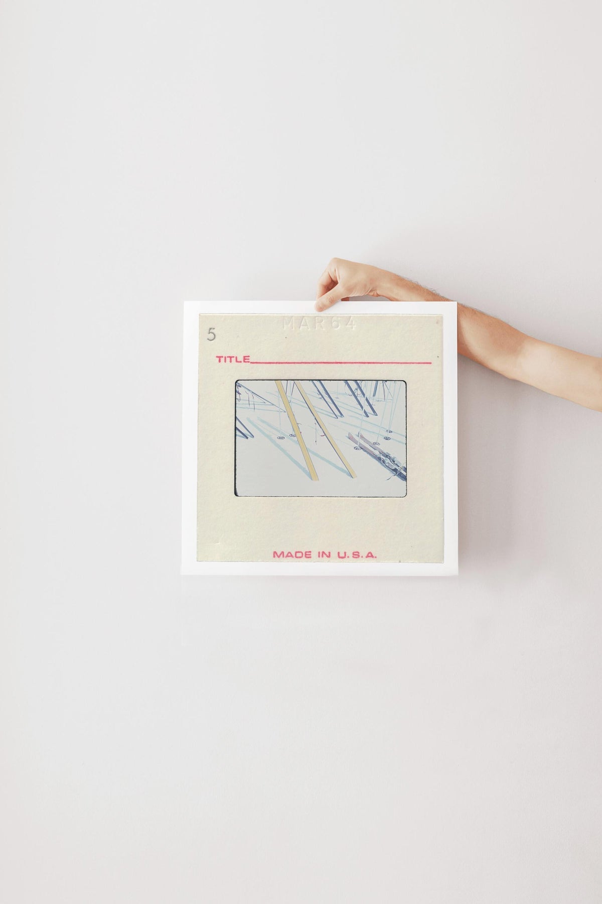 A person's hand is holding a framed image with a title and the text "MADE IN U.S.A."
