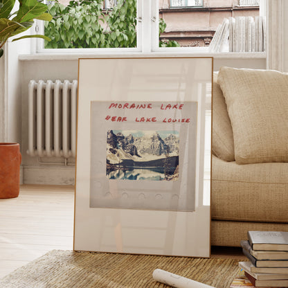 a framed photograph of a scenic mountain landscape, with the text "MORAIN LAKE" and "EAR LAKE LOUISE" written on it.