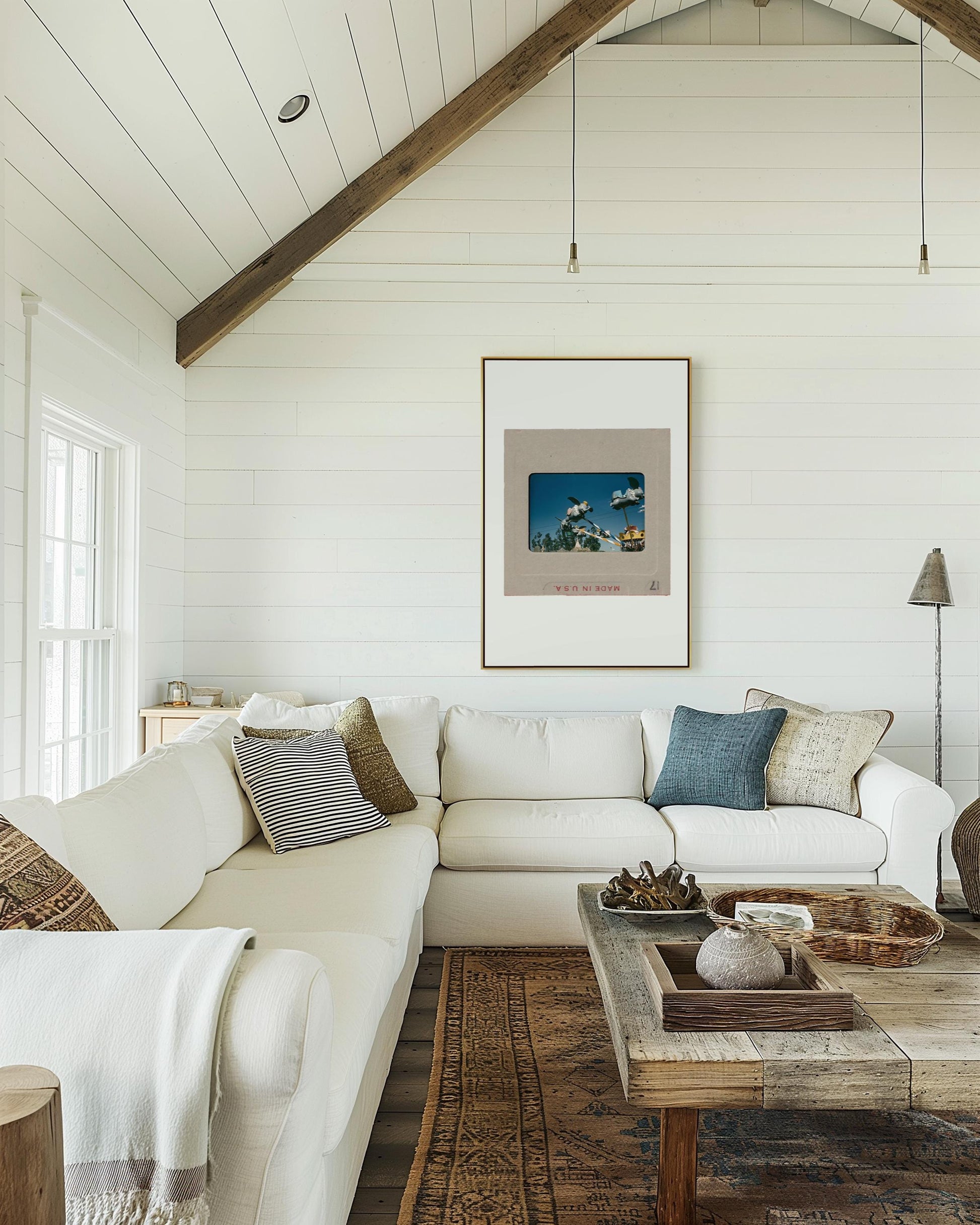 a cozy living room with a large white sectional sofa, a wooden coffee table, and a framed artwork on the wall.