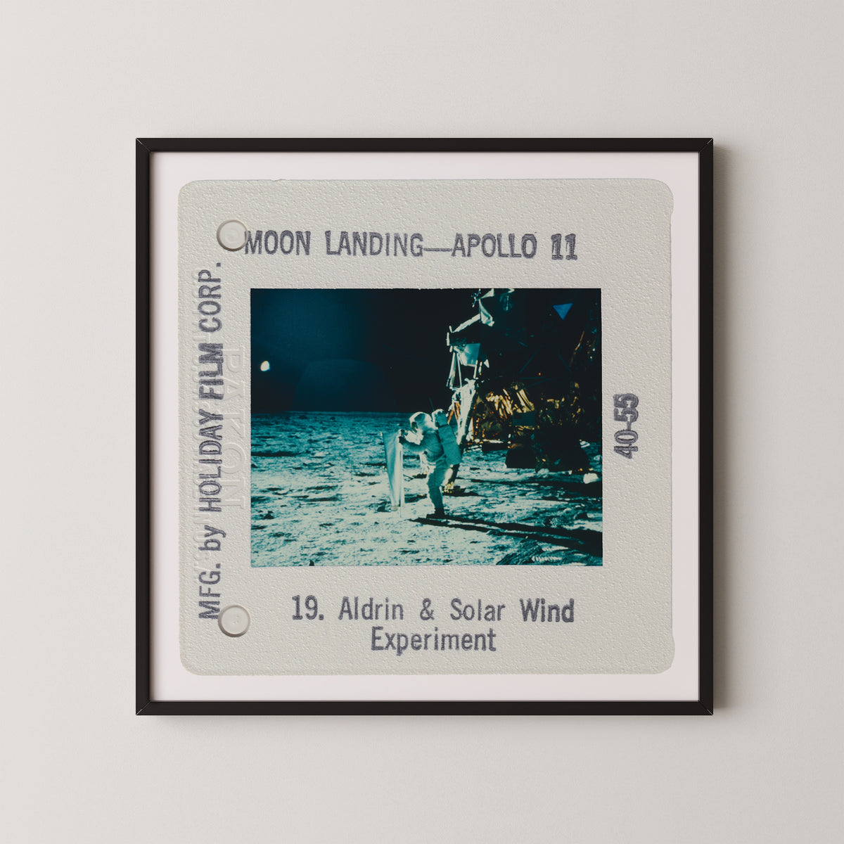 The image is a framed photograph of the Apollo 11 moon landing, featuring the astronaut Aldrin and the lunar module on the surface of the moon.