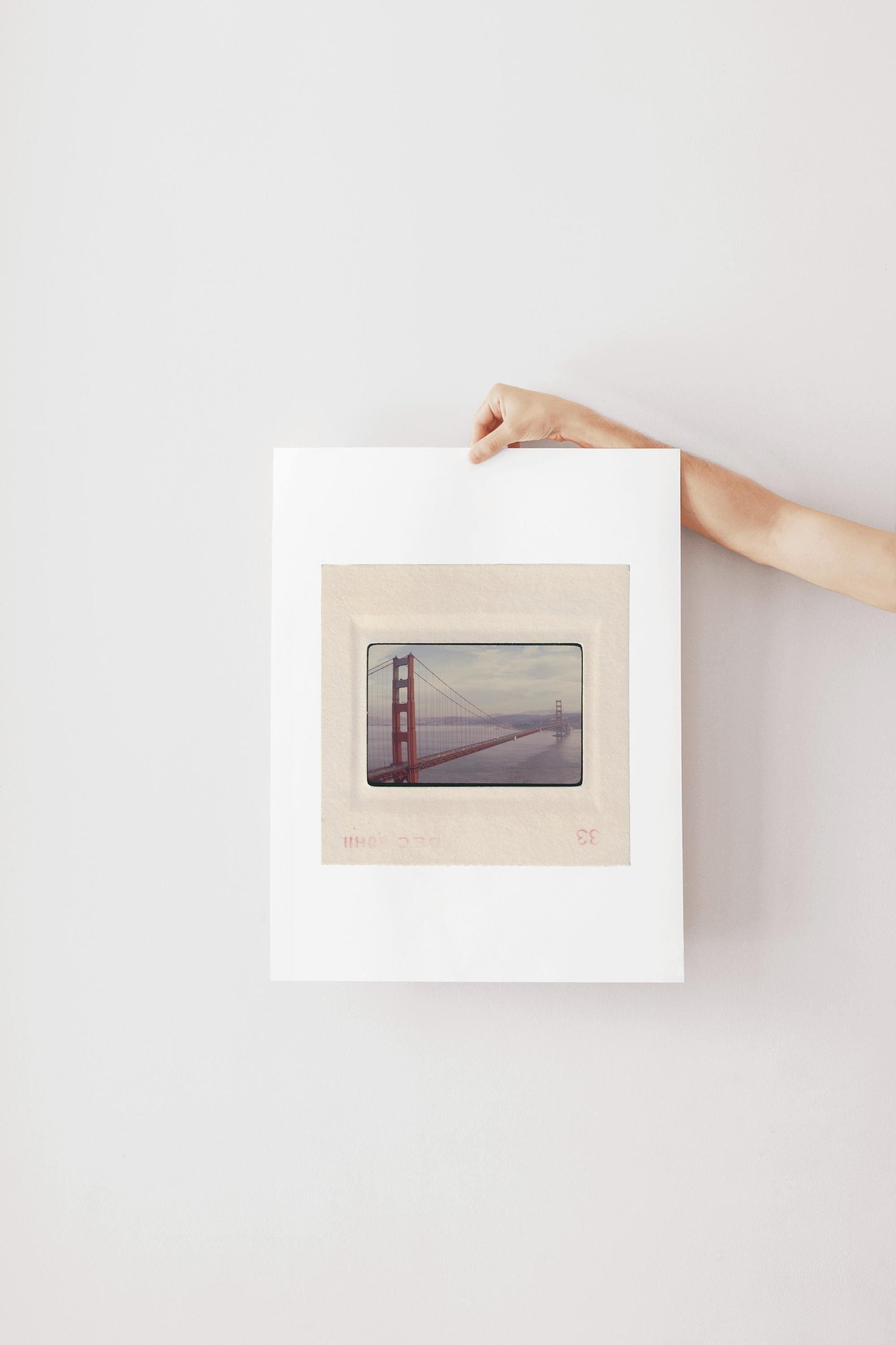 Vintage December 1958 color slide photograph of the Golden Gate Bridge's full span viewed from beside the north tower, sweeping dramatically across San Francisco Bay with cars on the deck and Marin hills in the background, printed as a fine art giclée print.