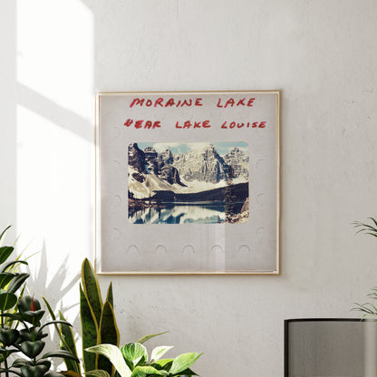 a framed photograph of a scenic mountain landscape, with the text "MORAIN LAKE" and "EAR LAKE LOUISE" written above it.