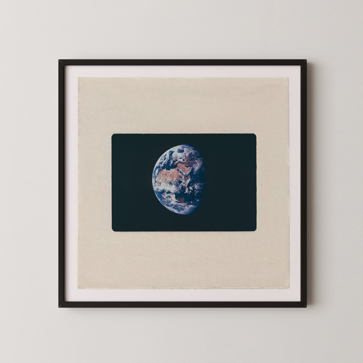 The image is a framed photograph of the Earth, depicting the planet's surface in a detailed and realistic manner.
