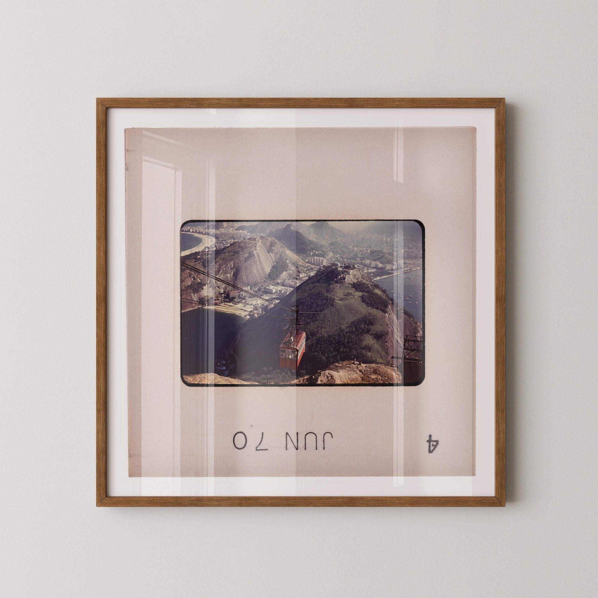 The image is a framed photograph of a mountainous landscape, with a small building visible in the distance.