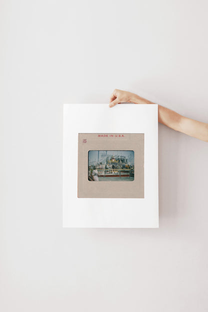 A person's hand is holding a framed photograph of a ship or boat, with the text "MADE IN U.S.A." visible on the frame.