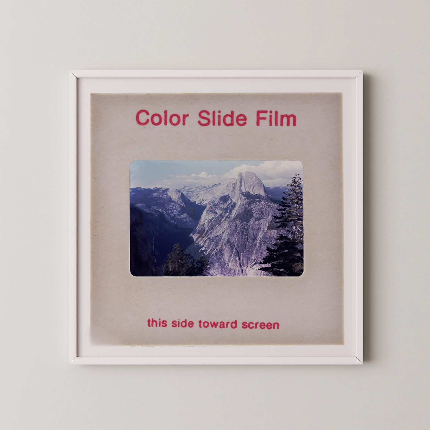 The image is a framed photograph of a mountainous landscape, with the text "Color Slide Film" and "this side toward screen" printed on the frame.