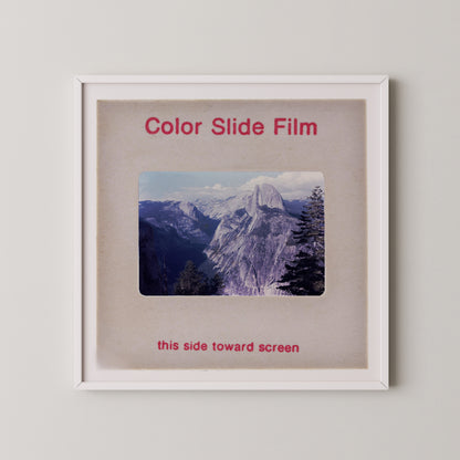 The image is a framed photograph of a mountainous landscape, with the text "Color Slide Film" and "this side toward screen" printed on the frame.