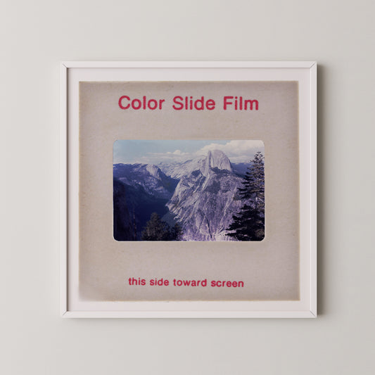 The image is a framed photograph of a mountainous landscape, with the text "Color Slide Film" and "this side toward screen" printed on the frame.
