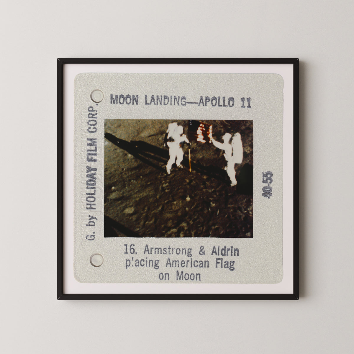 The image is a framed slide from a movie depicting the Apollo 11 moon landing, showing two astronauts walking on the surface of the moon.