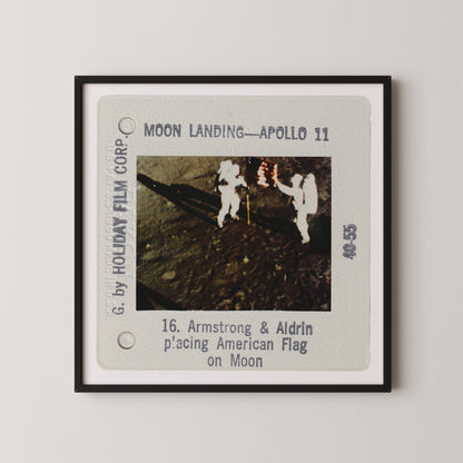 The image is a framed slide from a movie depicting the Apollo 11 moon landing, showing two astronauts walking on the surface of the moon.