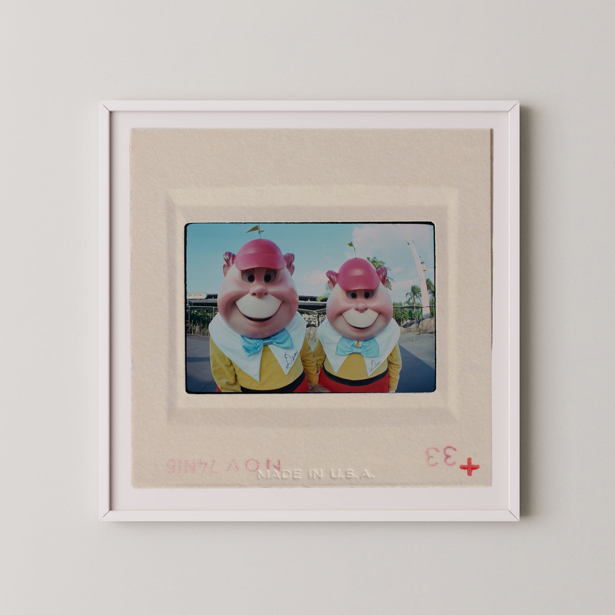 two cartoon characters wearing colorful outfits and hats, standing together in a frame.