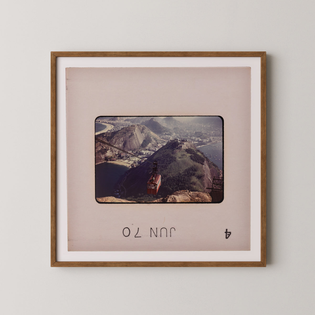 The image is a framed photograph of a mountainous landscape with a red building on a cliff.