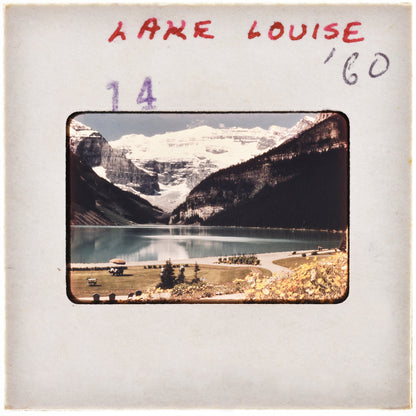 A framed photograph of a scenic mountain landscape with a lake and snow-capped peaks in the background.