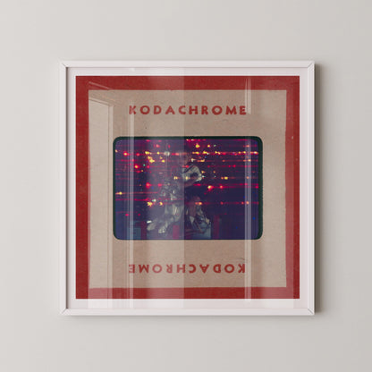 The image is a framed artwork featuring a photograph of a person in a dark room with a red and white color scheme.