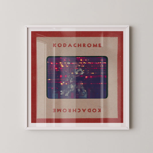 The image is a framed artwork featuring a photograph of a person in a dark room with a red and white color scheme.