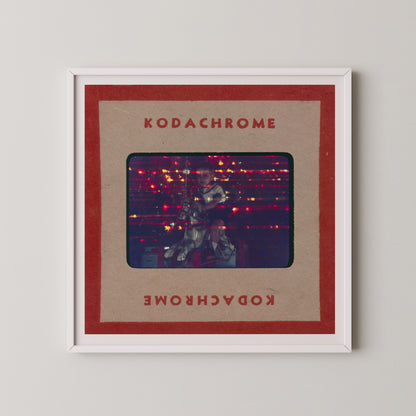 The image is a framed photograph of a person playing a guitar, with the text "KODACHrome" and "Kodachrome" written on the frame.