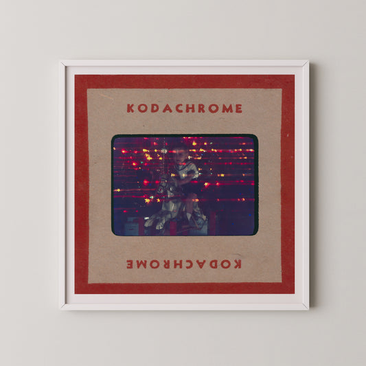 The image is a framed photograph of a person playing a guitar, with the text "KODACHrome" and "Kodachrome" written on the frame.