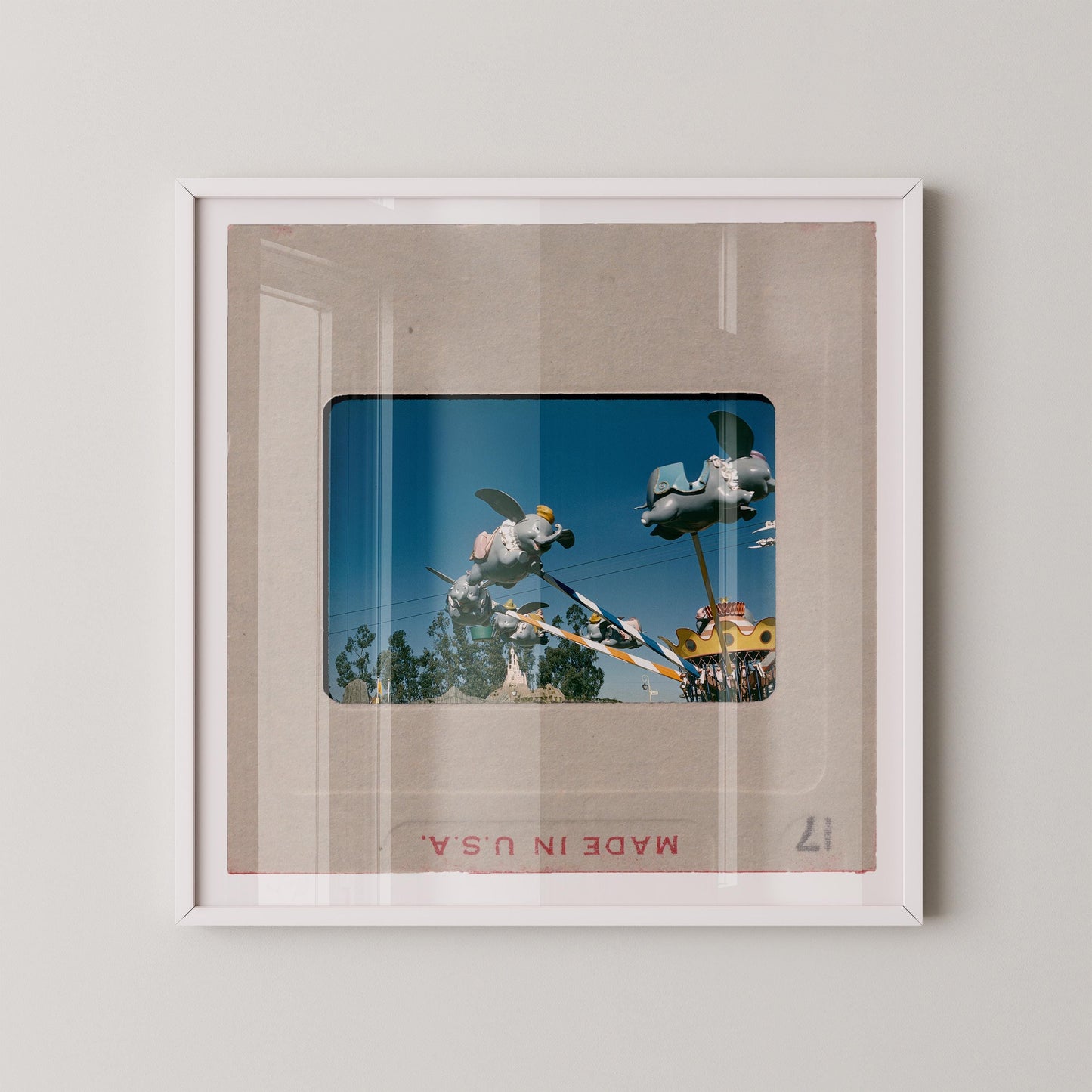 The image is a framed photograph of a carnival ride, featuring a large, colorful structure with various rides and attractions.