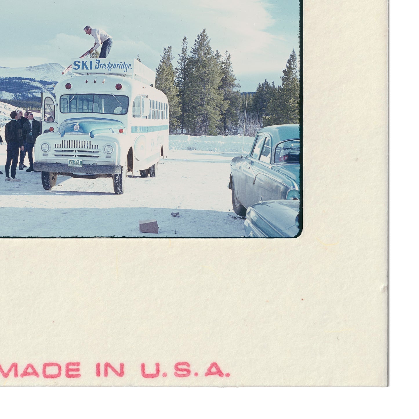A vintage ski bus parked in a snowy landscape, with people standing nearby.