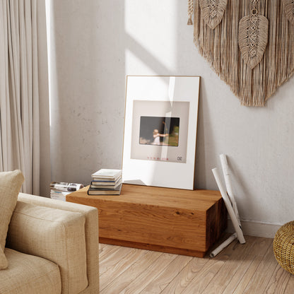 a cozy living room with a wooden coffee table, a framed photo, and a beige sofa.