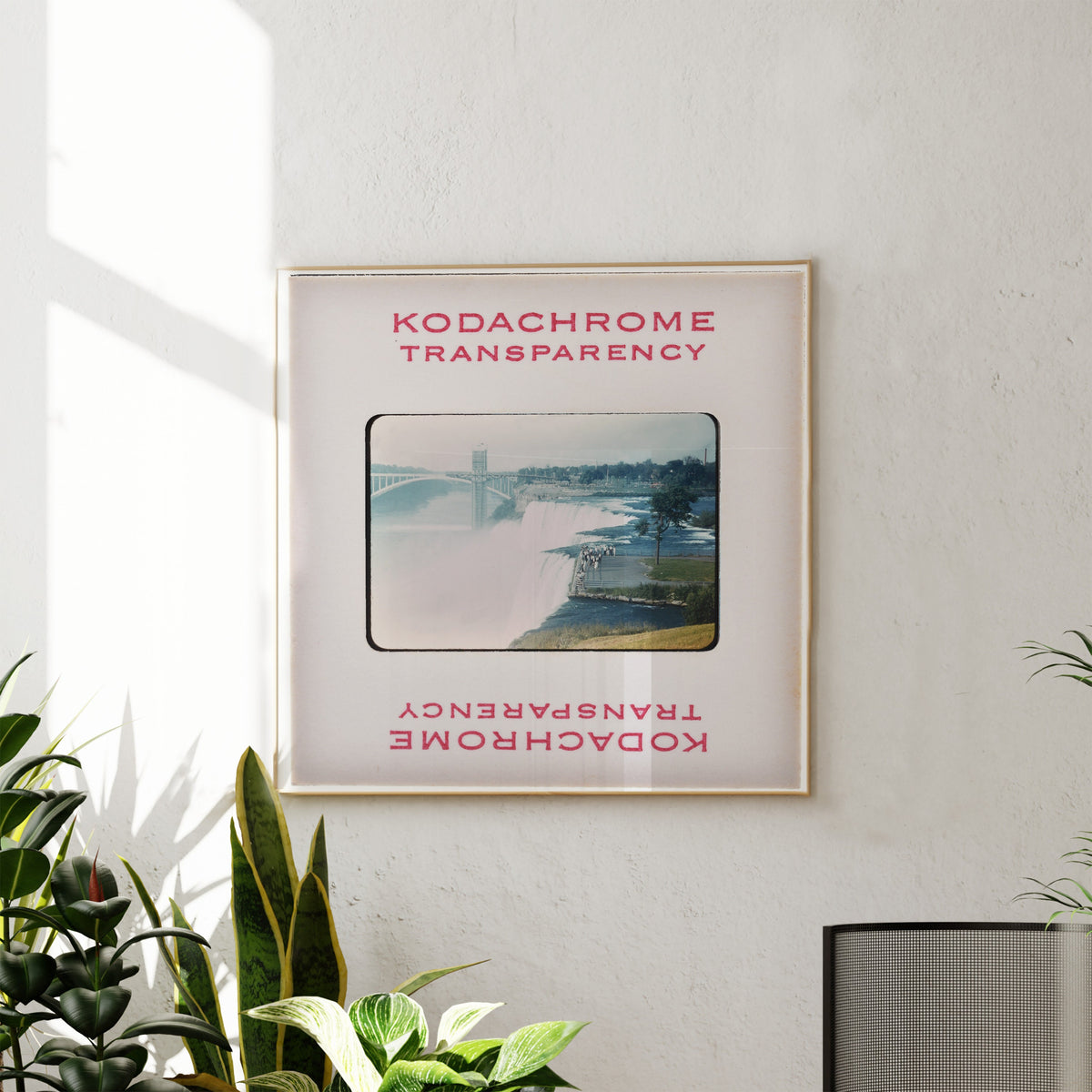 The image is a framed photograph of a waterfall, hanging on a wall.