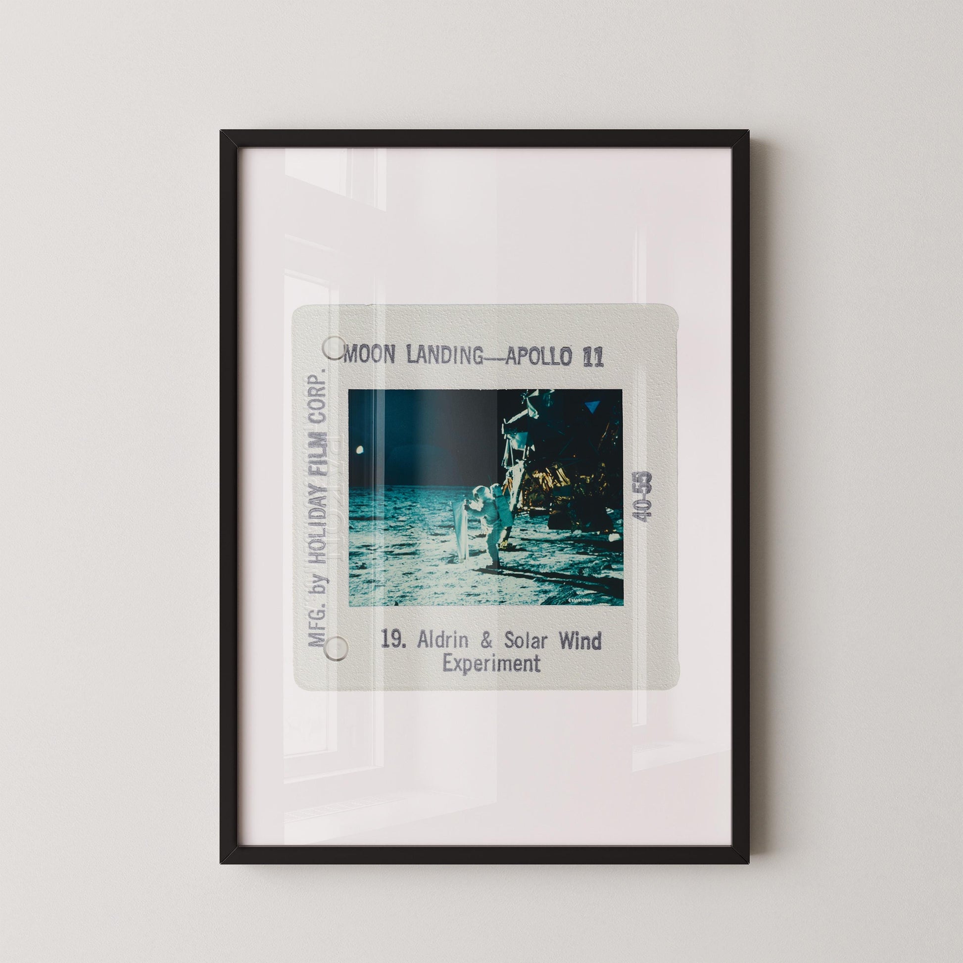The image is a framed photograph of the Apollo 11 moon landing, depicting the astronaut walking on the surface of the moon.