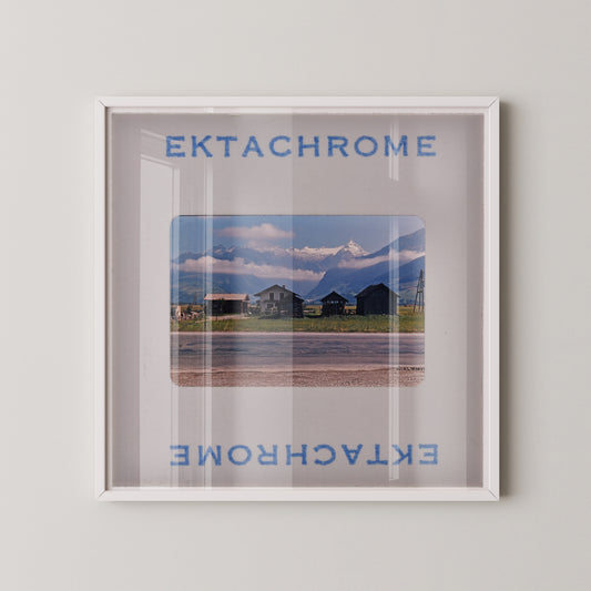 The image is a framed photograph of a scenic mountain landscape, with the text "EKTACHROME" and "EXTACHrome" visible at the top and bottom of the frame, respectively.