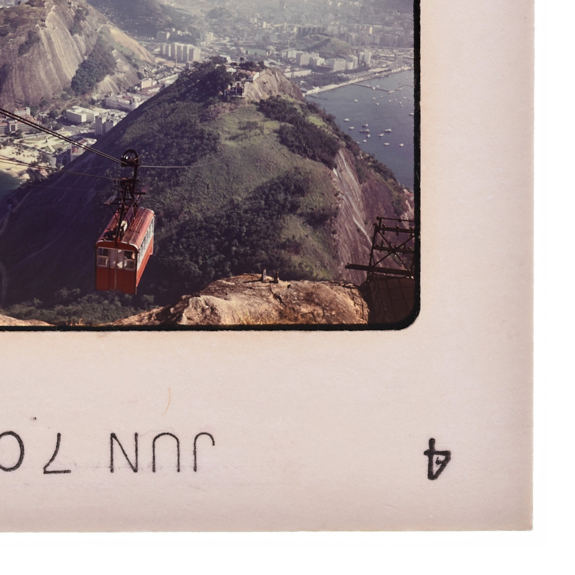 a cable car system suspended above a mountainous landscape, with a city visible in the background.