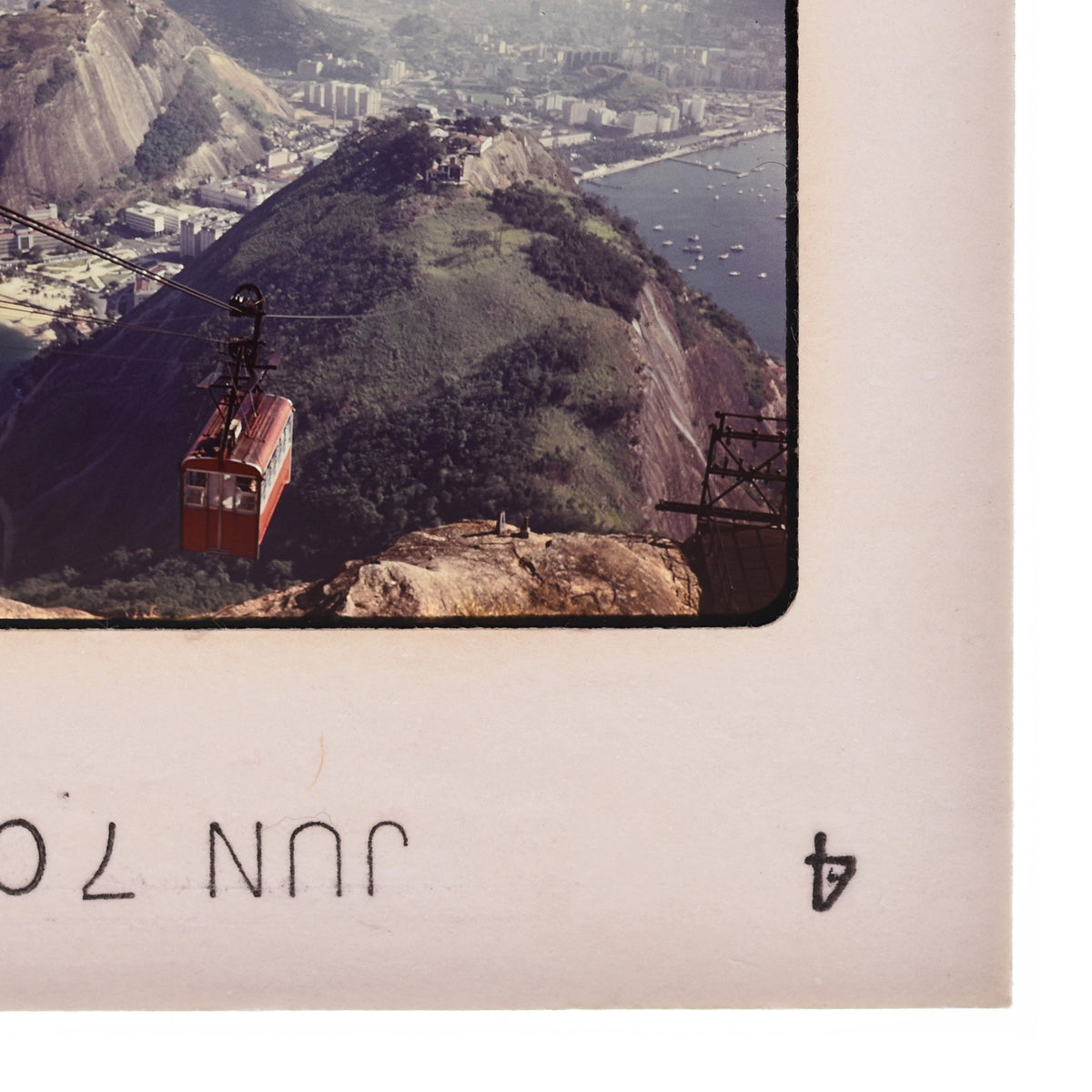 a cable car system suspended above a mountainous landscape, with a city visible in the background.