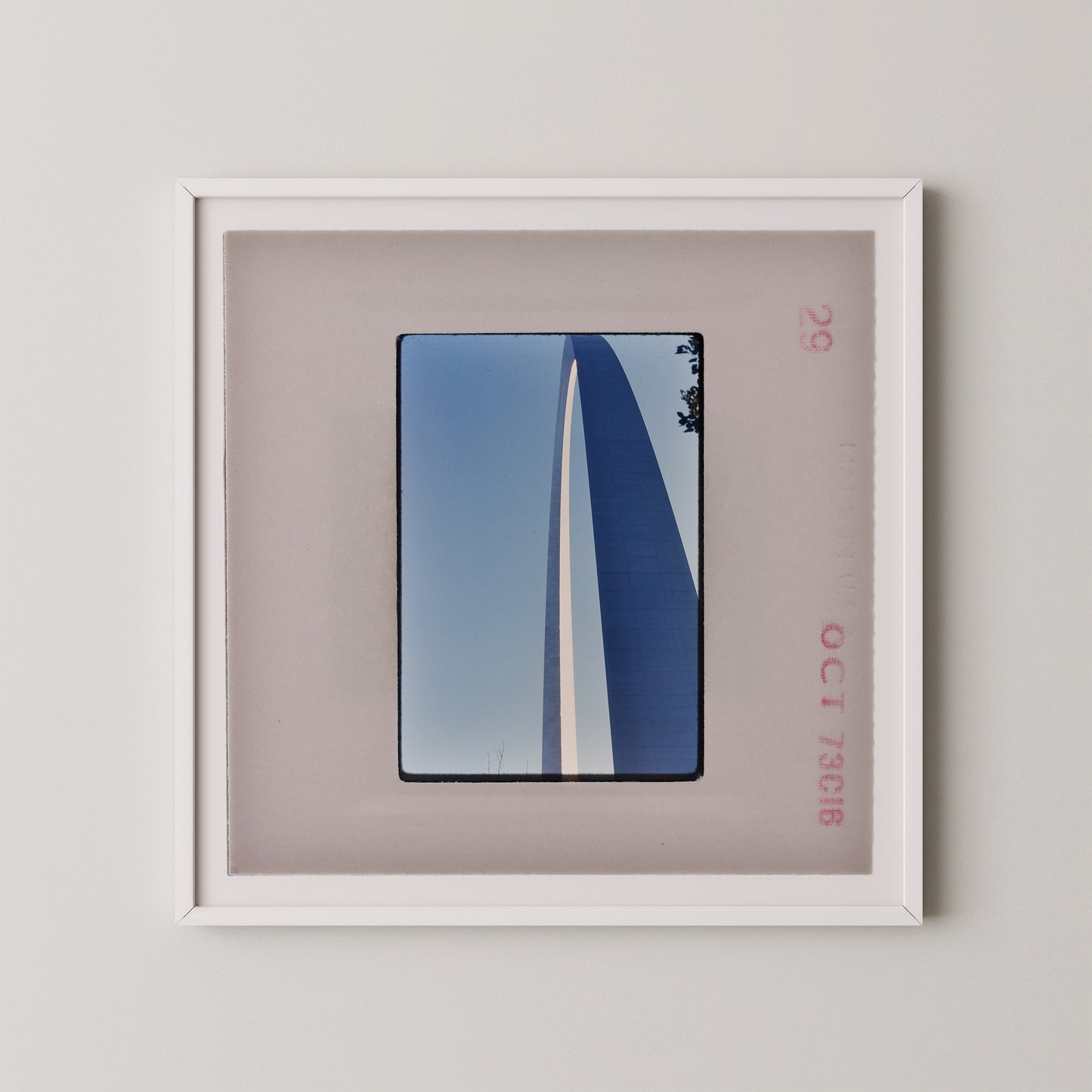 a framed photograph of a tall, blue structure with a white stripe, displayed on a wall.