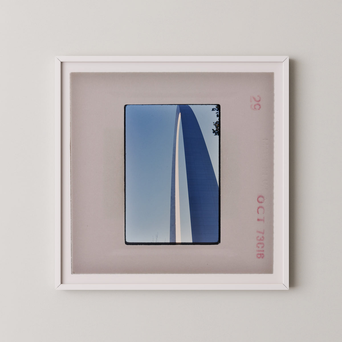a framed photograph of a tall, blue structure with a white stripe, displayed on a wall.